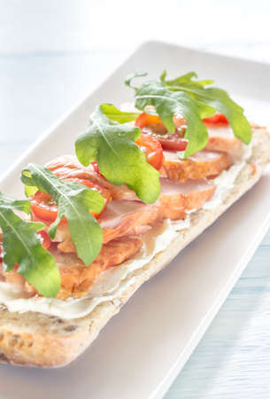 Sandwich with cream cheese, smoked chicken, cherry tomatoes and arugulaの写真素材