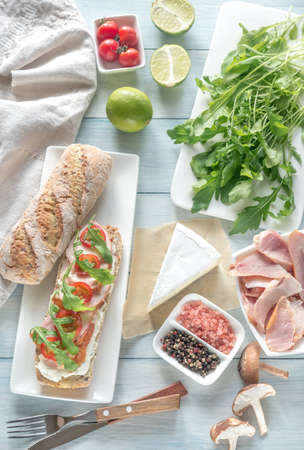 Sandwich with cream cheese, smoked chicken, cherry tomatoes and arugulaの写真素材