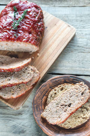 Meat loaf with tomato sauce on the wooden boardの写真素材