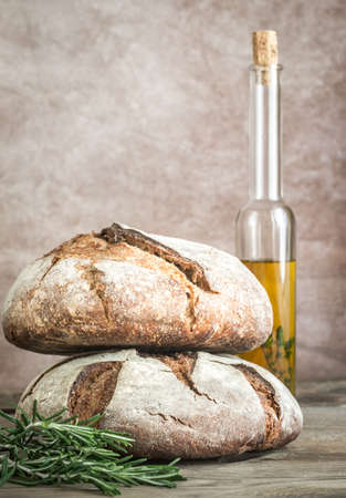 Loaves of bread with olive oil and fresh rosemaryの写真素材