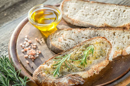 Slice of fresh bread with olive oil and herbsの写真素材