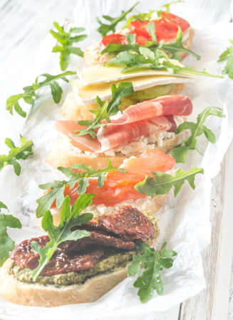 Crostini with different toppings on the wooden backgroundの写真素材