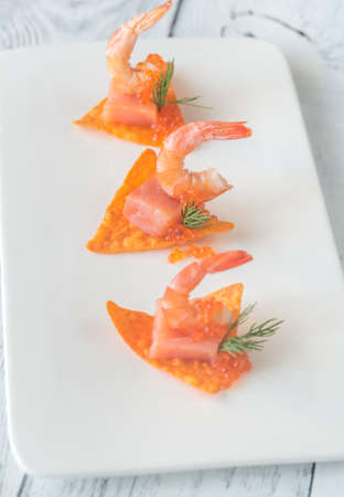 Corn chips with shrimps and salmonの写真素材