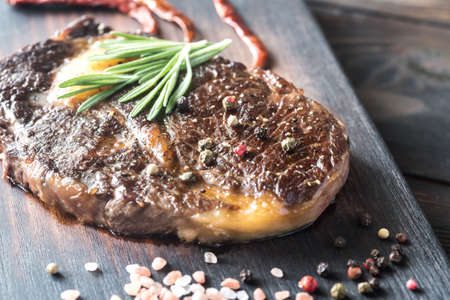 Beef steak with fresh rosemary on the wooden boardの写真素材
