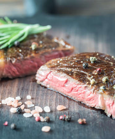 Beef steak with fresh rosemary on the wooden boardの写真素材