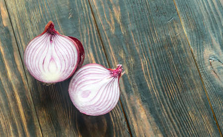 Red onion on the wooden background: cross sectionの写真素材