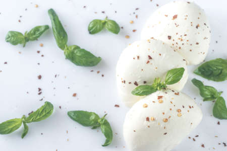 Mozzarella with basil leaves on the white backgroundの写真素材