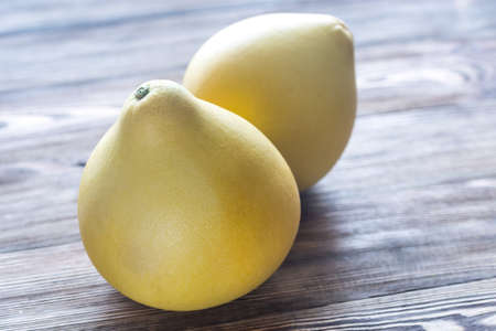 Two pomelos on the wooden background