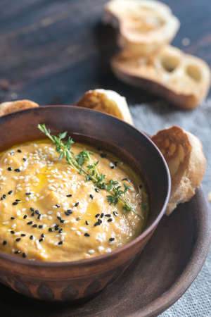 Bowl of pumpkin hummus with slices of toasted breadの写真素材