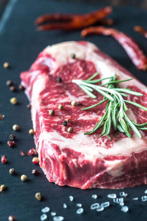 Raw beef steak with fresh rosemary on the boardの写真素材