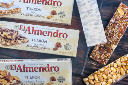 SUMY, UKRAINE - DEC 8, 2017: El Almendro turron packs on the wooden board. Turron is confection made...