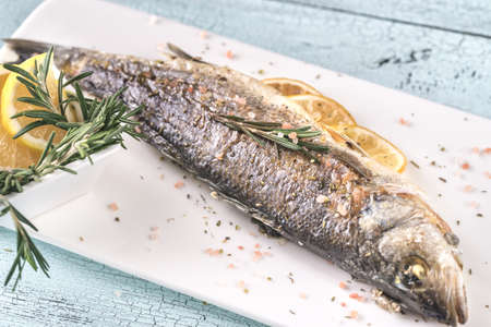 Baked sea bass with lemon and rosemaryの写真素材