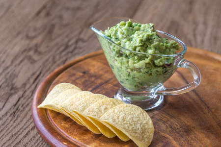 Guacamole with chips on the wooden boardの写真素材