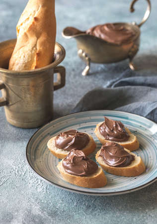 Slices of baguette with chocolate cream on the plateの写真素材