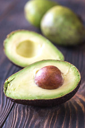 Halved avocado on the wooden background
