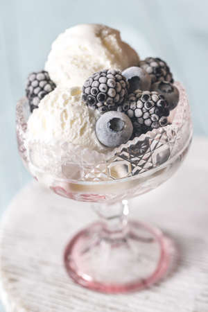 Vanilla ice cream with fozen berries in the glass vase