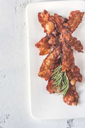 Fried bacon strips on the white plateの写真素材