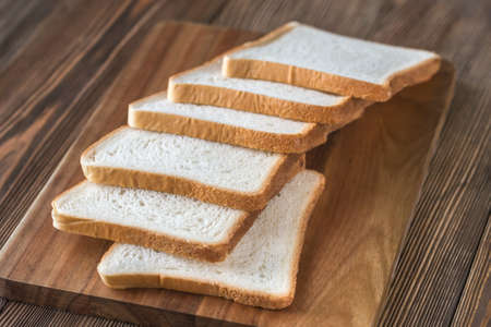 Slices of white bread on the wooden boardの写真素材