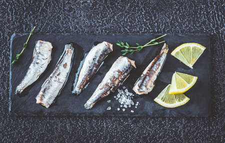 Sardines on the black stone board: top view