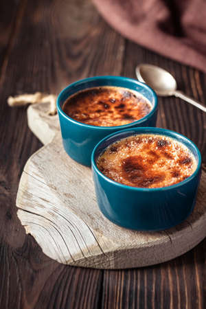 Creme brulee in the pots on the wooden board