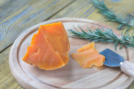 Wedge of Mimolette cheese on the wooden boardの写真素材