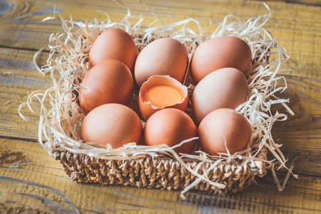 Basket of raw chicken eggs on the wooden background