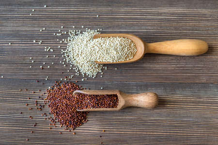 Scoops of raw white and red quinoa on the wooden backgroundの写真素材