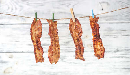 Slices of fried bacon on the wooden