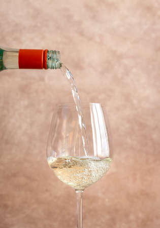 White wine pouring into glass close-up