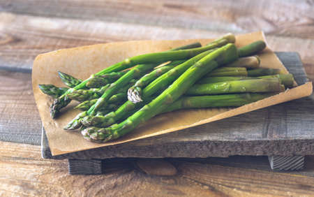 Bunch of cooked asparagus on the wooden boardの写真素材