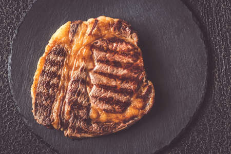Grilled beef steak on the black stone board: top viewの写真素材