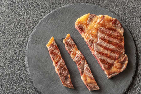 Grilled beef steak on the black stone board: top viewの写真素材