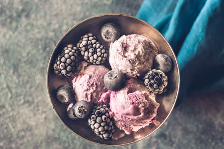 Fruit ice-cream with fresh blueberries and blackberries in vintage vaseの写真素材