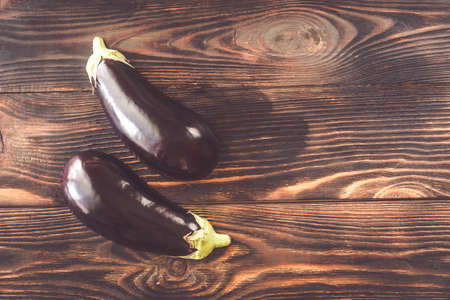 Two halves of aubergine on the wooden background: top viewの写真素材