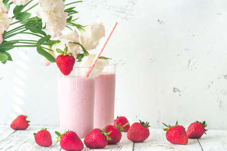 Two glasses of strawberry shake with fresh strawberriesの写真素材
