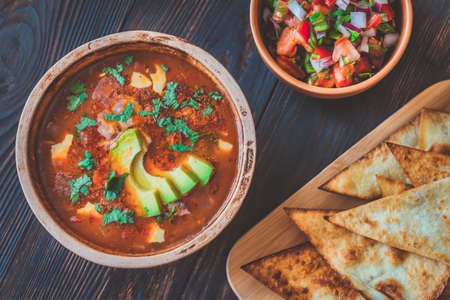 Bowl of spicy Mexican soup with grilled tortillas and salsaの写真素材