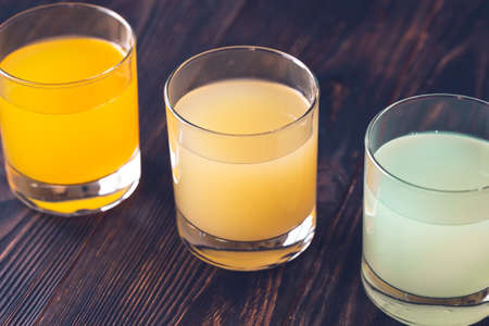 Assortment of citrus juices on the wooden backgroundの写真素材