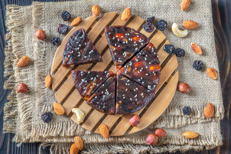 Pressed fruit and nut cake on the rustic background