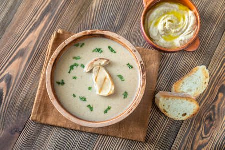 Creamy mushroom soup with toasted baguette and hummusの写真素材