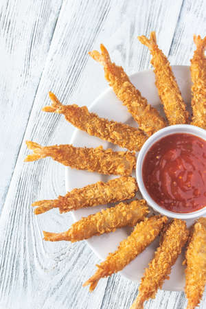 Shrimp tempura with sauce on the plate: top view
