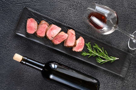 Bottle of red wine with sliced filet mignon: top viewの写真素材