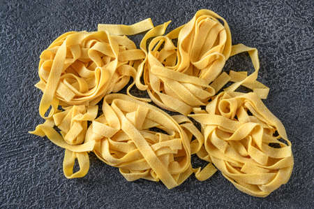 Raw pappardelle - flat Italian pasta noodles on wooden backgroundの写真素材