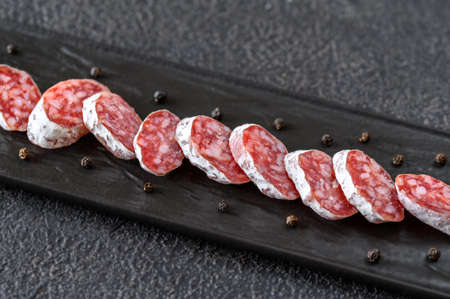Fuet -  Catalan dry cured sausage on the black serving plate