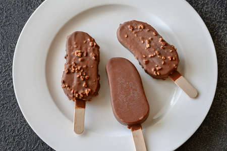 Chocolate-covered vanilla ice cream bars on the white plate