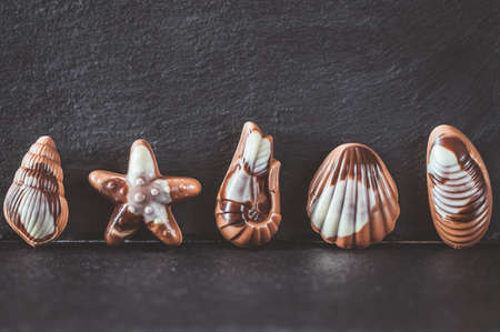 Seafood-shaped chocolate candies on stone board