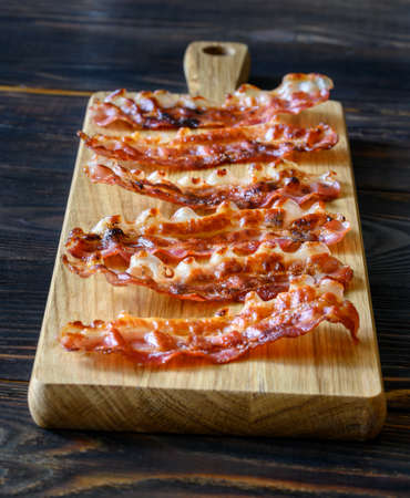 Fried bacon strips on the wooden boardの写真素材