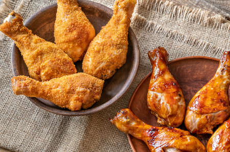 Breaded and grilled chicken drumsticks on rustic backgroundの写真素材