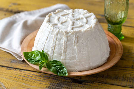 Ricotta an Italian whey cheese with fresh basil leavesの写真素材