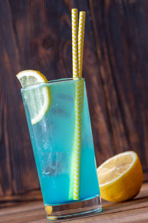 Glass of electric lemonade cocktail garnished with lemonの写真素材