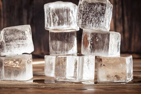 Crystal clear ice cubes on wooden backgroundの写真素材